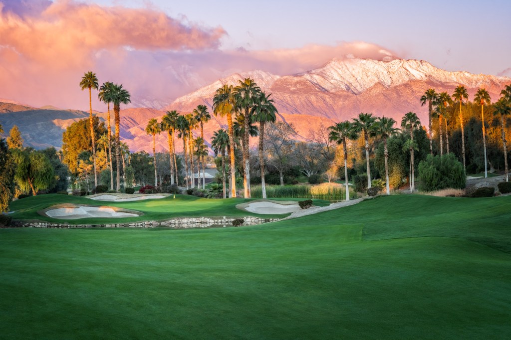 the green of golf course and sun hitting mountains